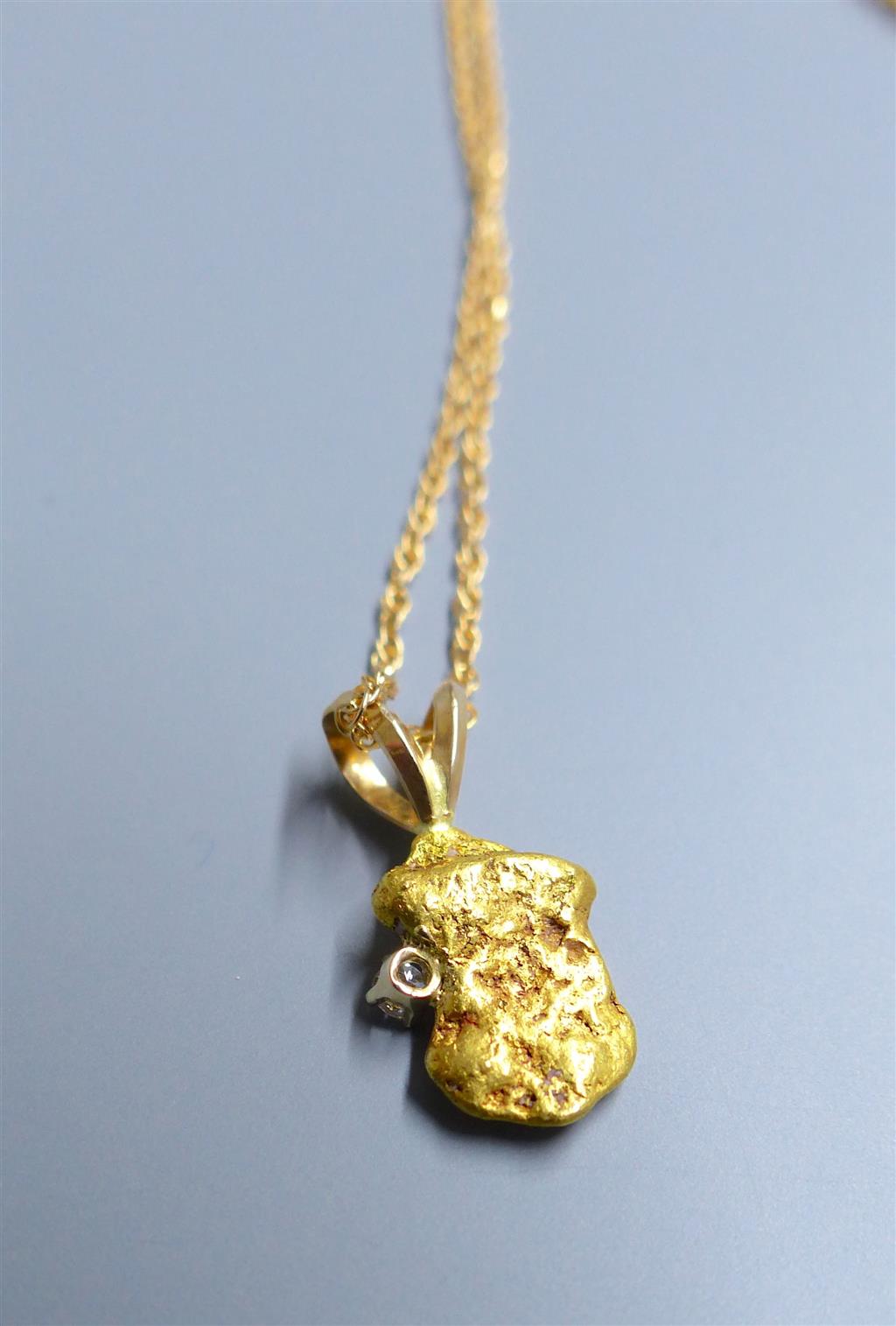 A diamond set gold nugget pendant, 12mm, gross 2.1grams, on a 585 fine link chain, 1.4 grams.